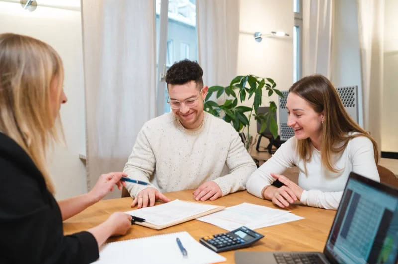 Junges Paar wird persönlich zur Elterngeldberatung beraten – entspannte Atmosphäre